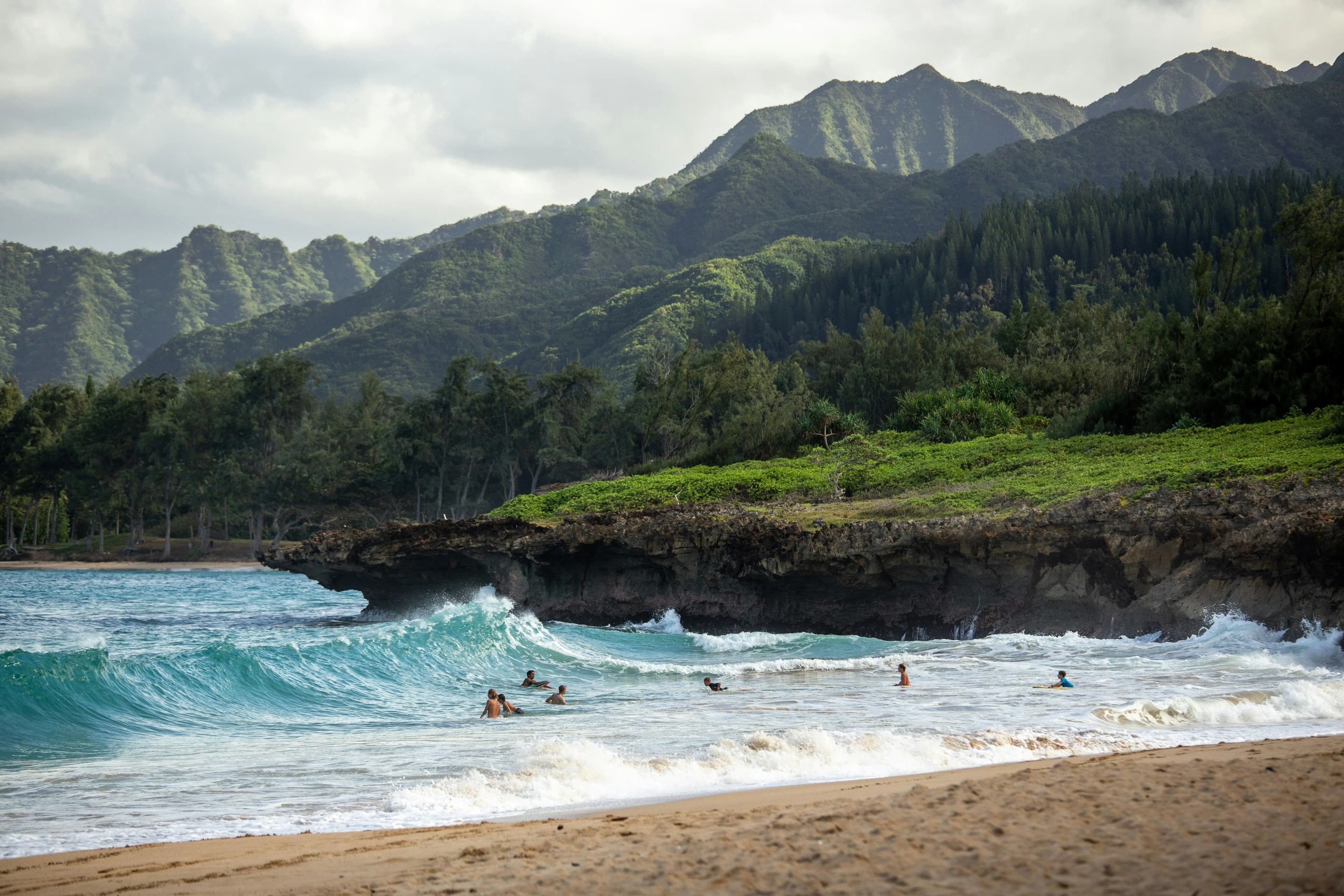 Hawaiian coastline framed by green mountains and the Pacific Ocean