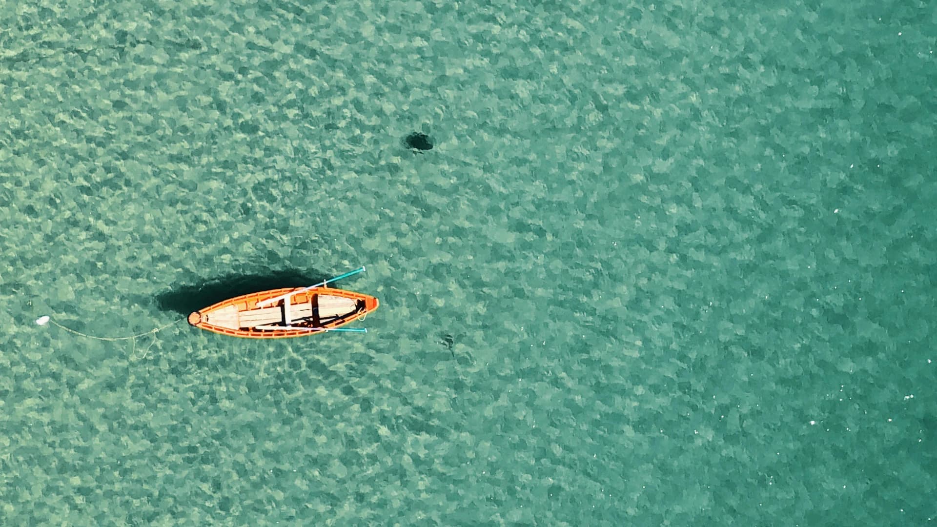 A small boat floating on clear turquoise water